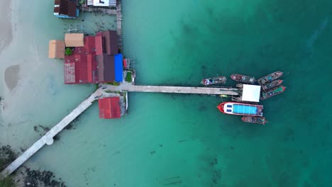 cambodia koh rong island, capturing the essence of tropical paradise with its lush palm trees, vibrant turquoise waters, and traditional stilt houses. stunning aerial view flight ascending drone