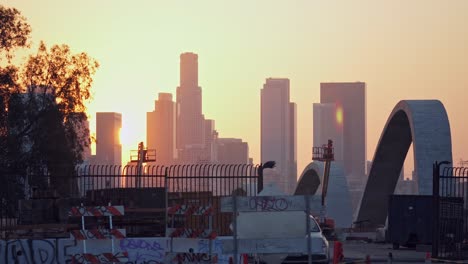 cinematic locked off shot at sunrise over the 6th street bridge redevelopment in la and with the los angeles skyline on the horizon