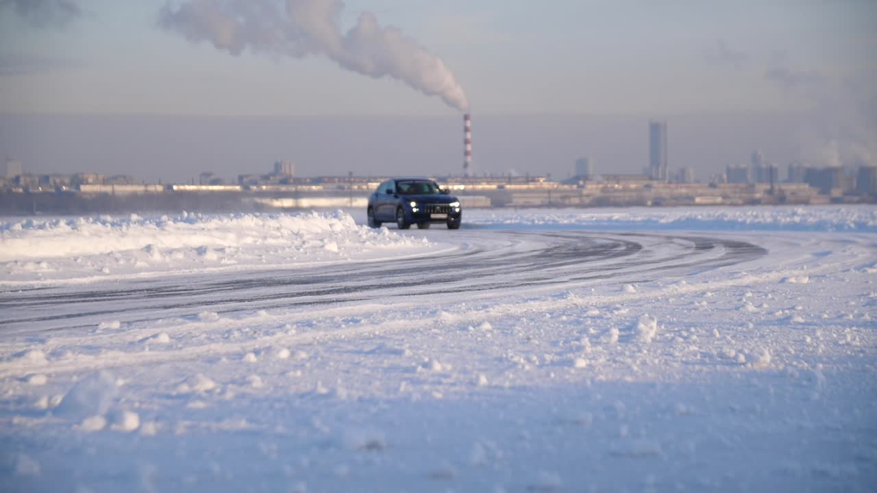 автомобиль едет по заснеженной трассе в зимнем городском пейзаже