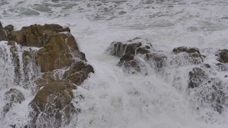 Ola-Rompiendo-En-Las-Rocas-Con-Espuma-Blanca-En-Cámara-Súper-Lenta