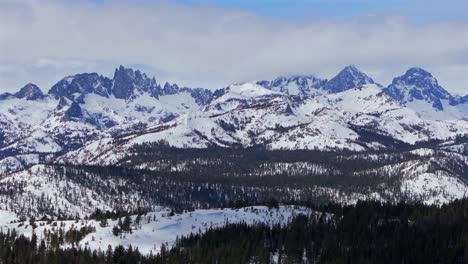 minarets jagged towering peaks vista point panoramic landscape mammoth mountain ski resort aerial drone california winter spring sunny blue sky morning clouds hemlocks inyo national forest backwards