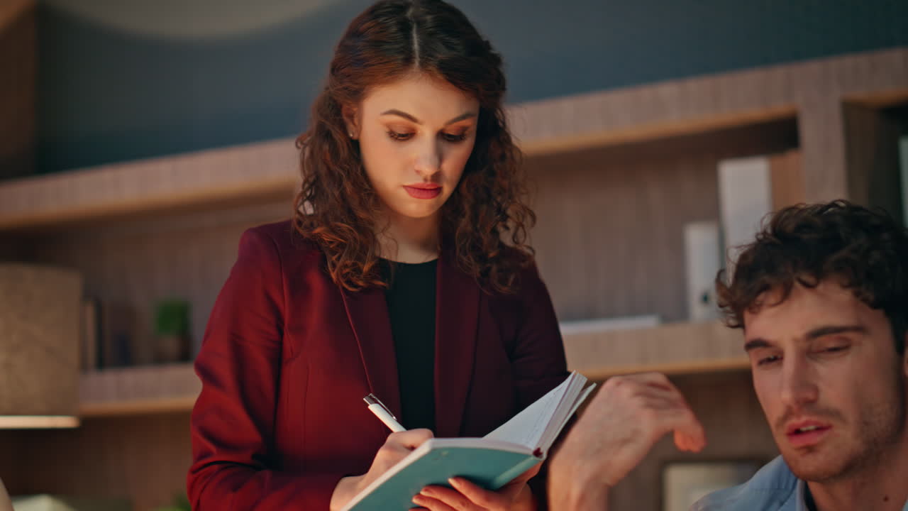 Two businesspeople solving business issues working together late evening closeup