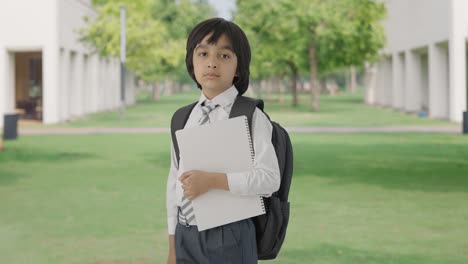 retrato de un niño de escuela indio confiado de pie con libros