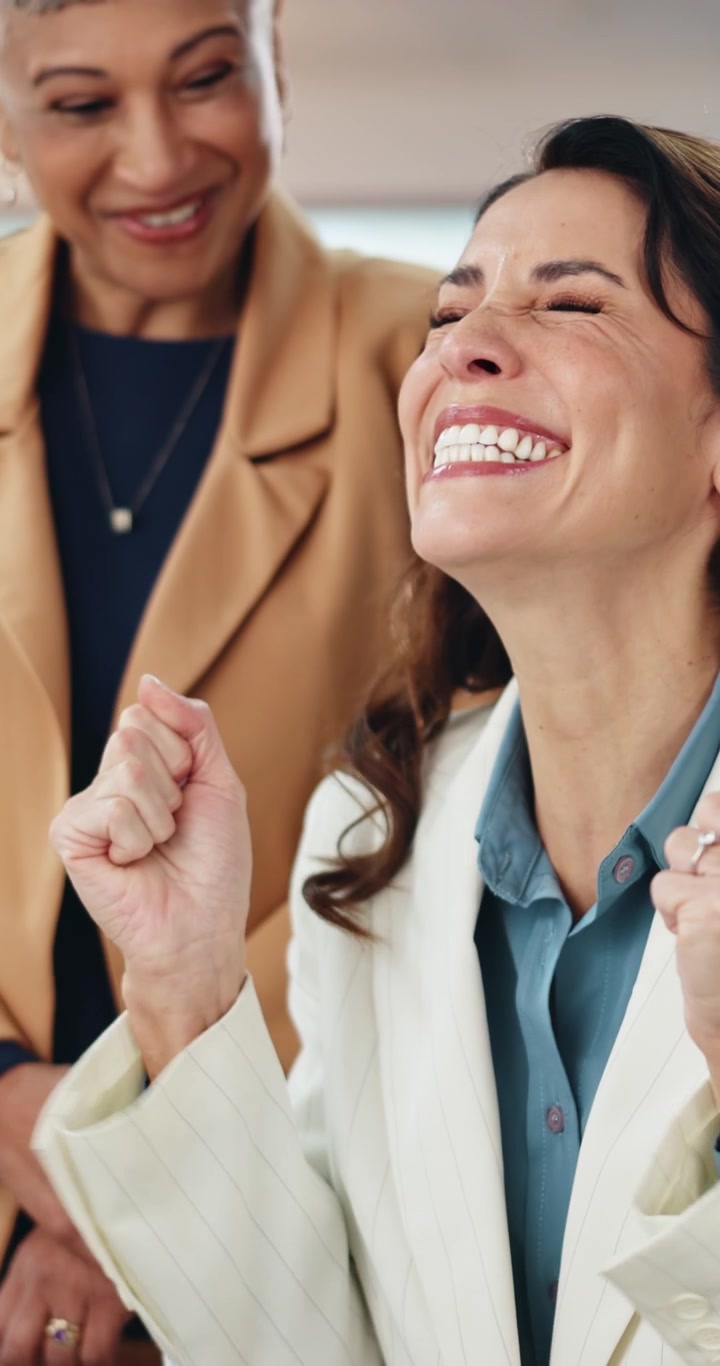 Due donne professioniste che festeggiano il successo in ufficio