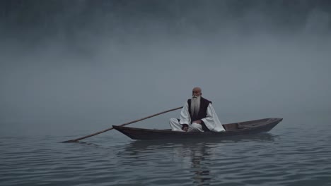 hombre anciano en un bote en un lago de niebla