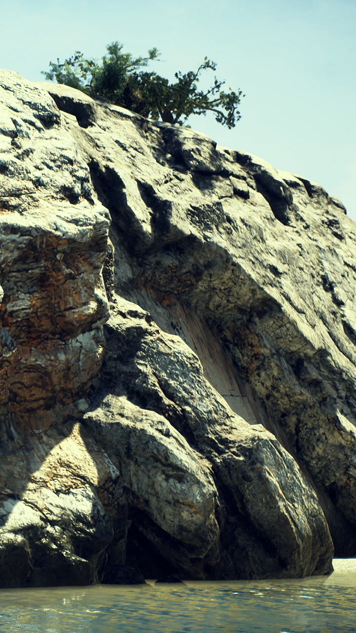 Calm waters reflect rugged cliffs under a bright sunny sky