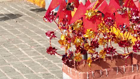 a colorful arrangement of red and yellow flowers with decorative elements on a paved surface.