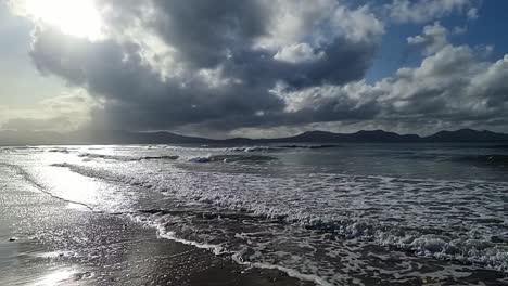 Zeitlupenaufnahme-Von-Sanften-Wellen,-Die-Am-Sandstrand-Krachen,-Herrlicher-Bewölkter-Himmel