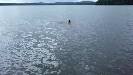 man swimming in a lake