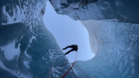 climber repels down a glacier moulin