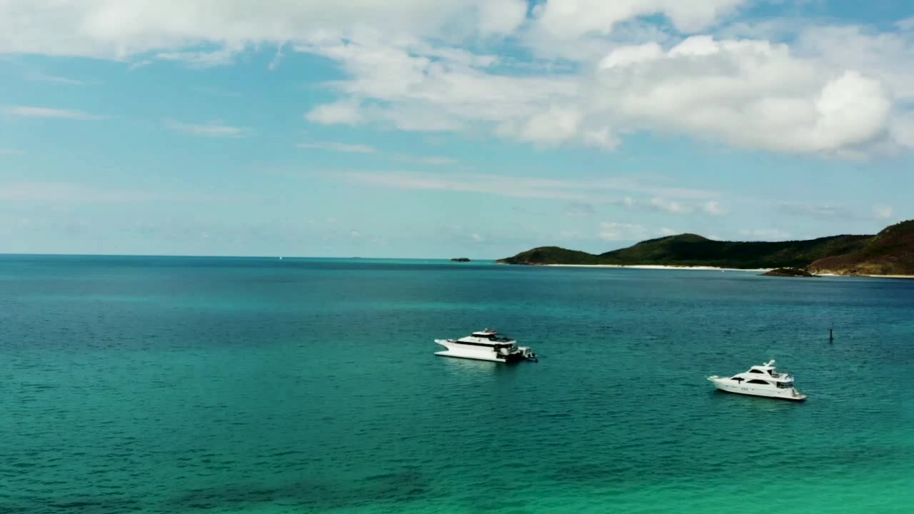 drone volando hacia arriba mientras filma barcos en la distancia