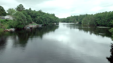 Aerial-video,-low-altitude,-over-pond-with-surrounding-trees-in-Burrillville,-RI