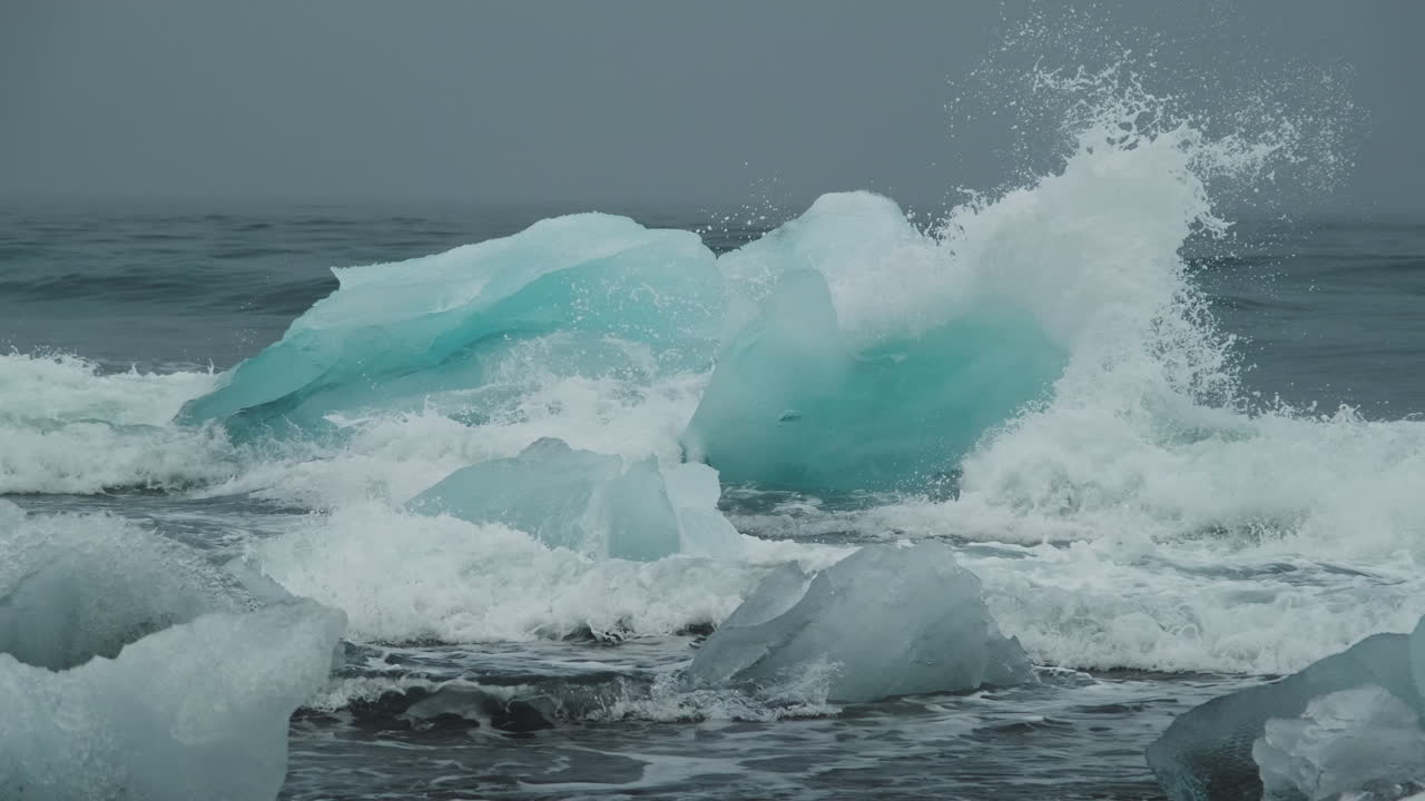 Ocean waves over melting blue glacial ice