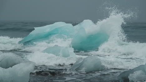ocean waves over melting blue glacial ice