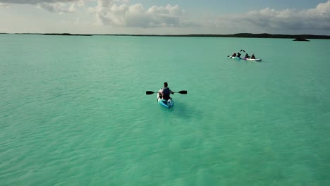 aerial drone shot of a tourist riding a boat on the coast of south caicos surrounded by a blue and exotic caribbean sea, turks and caicos islands 4k