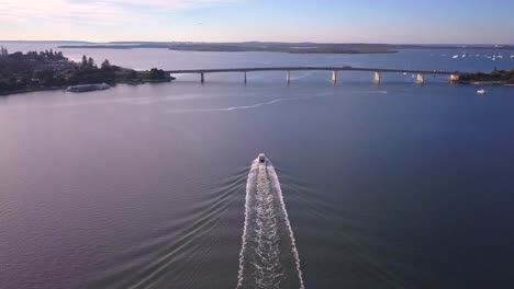 aerial speed boat chasing and following by the drone at golden hour sunrise