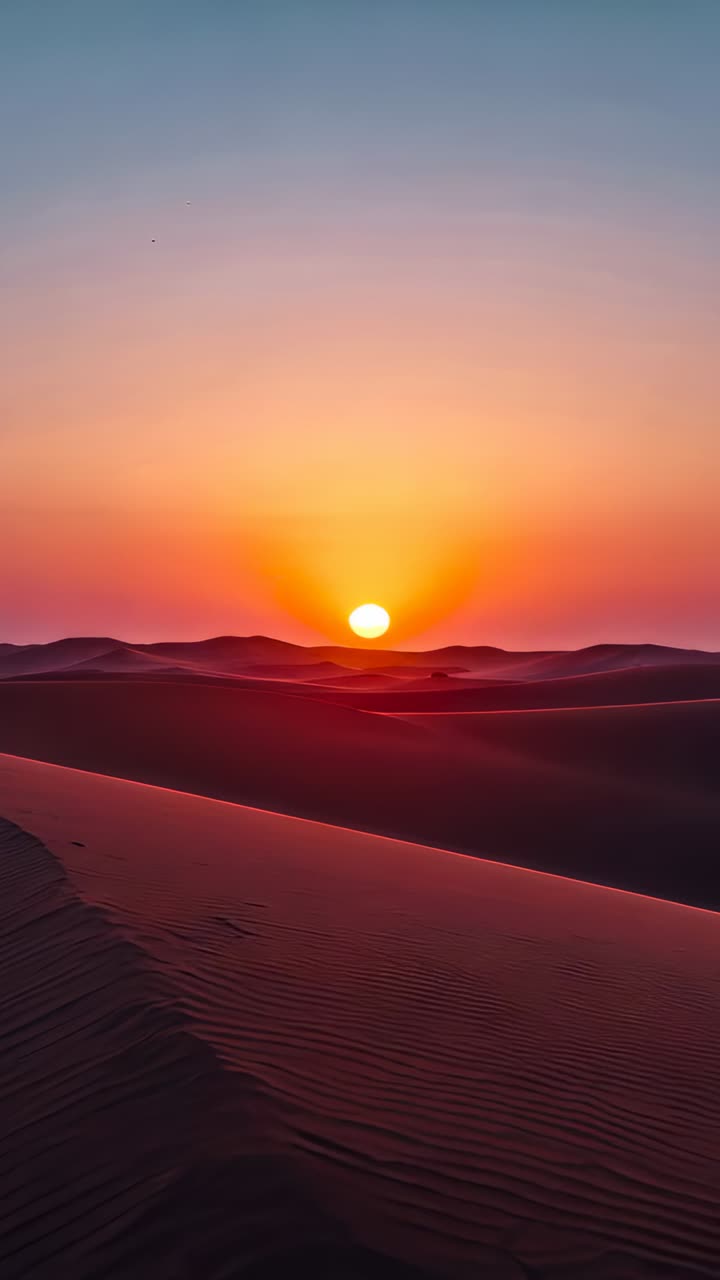 Vertical video: Bathing central dune field, sun moving at desert horizon and tracing rippled dunes