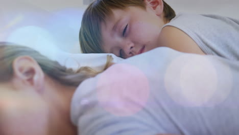 animación de puntos de luz sobre madre y hijo caucásicos durmiendo