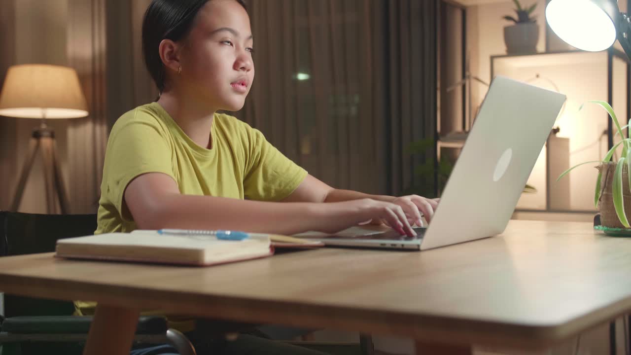 Asian Kid Girl Sitting Use Laptop Computer And Thinking About Something Then Raising Her Index Finger, Eyes Wide Open At Home