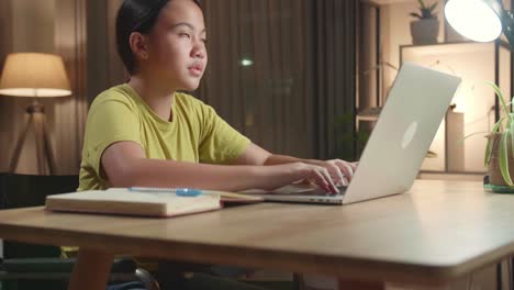 asian kid girl sitting use laptop computer and thinking about something then raising her index finger, eyes wide open at home