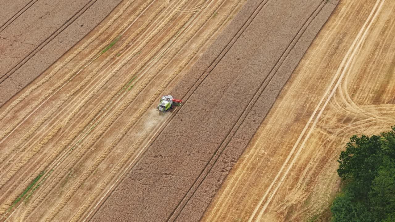 Aerial view of machines harvesting grain in wide open fields
