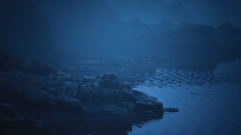 misty evening on a tranquil lakeside with rocky formations and gentle waves
