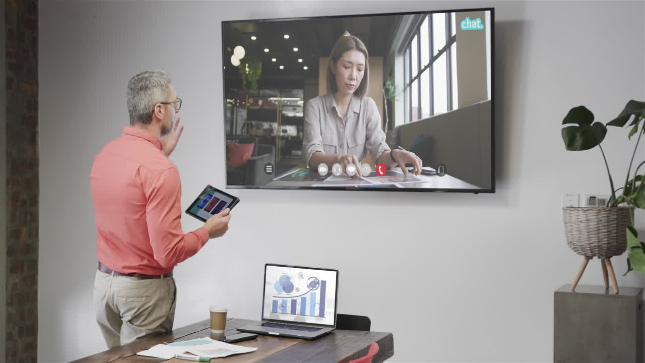 hombre de negocios caucásico en videollamada con una colega caucásica en la pantalla de televisión
