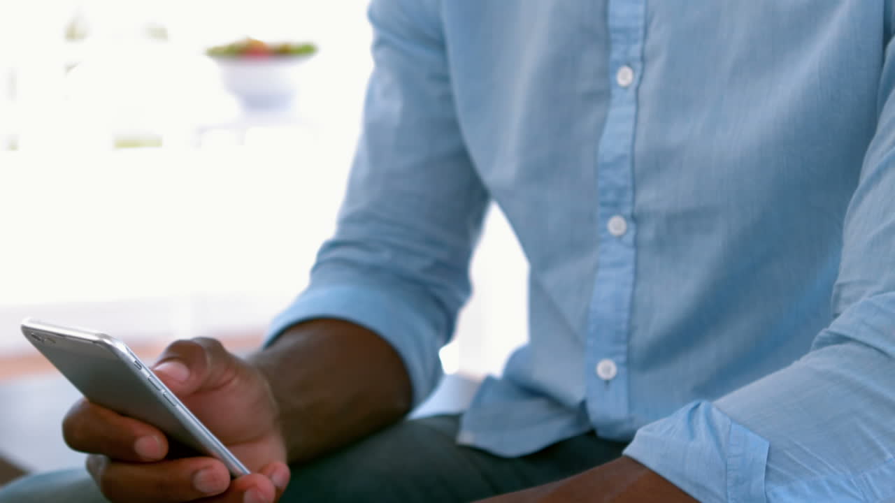Man sending a text sitting on couch