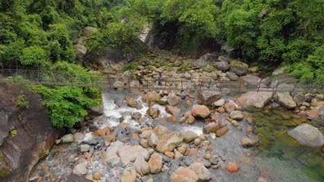 Toma-Aérea-De-4k-De-Personas-Caminando-En-Un-Puente-Colgante-En-Los-Bosques-De-Cheerapunji,-Meghalaya,-India