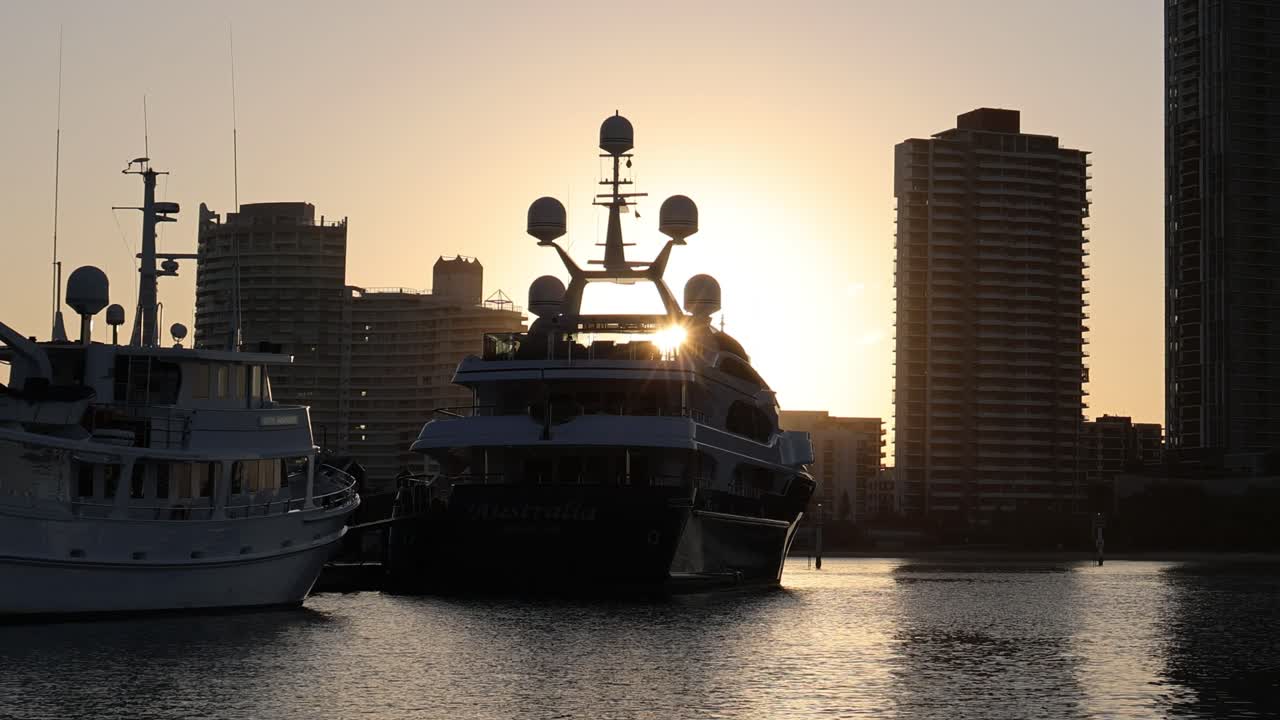 Sole che tramonta dietro yacht in un porto turistico cittadino