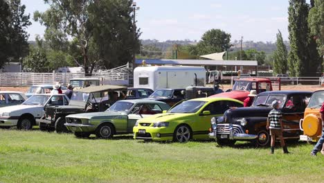 personas admirando coches clásicos en un evento al aire libre