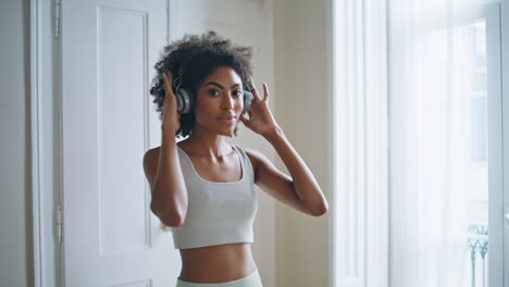 Señora-Deportiva-Con-Auriculares-En-Primer-Plano-De-Casa.-Mujer-De-Pelo-Rizado-Amasando-El-Cuello