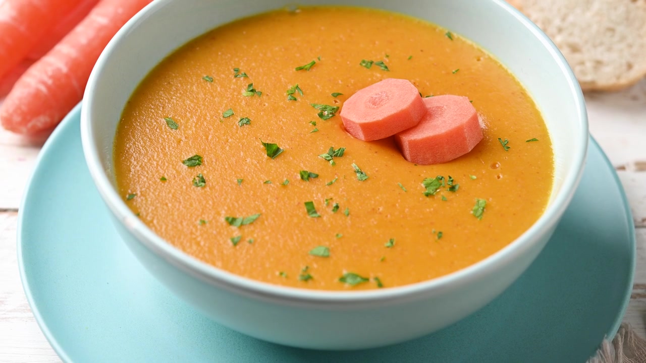 Cremet gulerodssuppe i en blå skål.