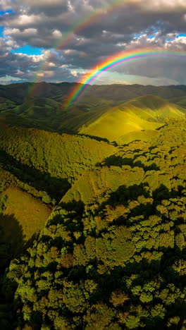double rainbow over mountainous forest landscape