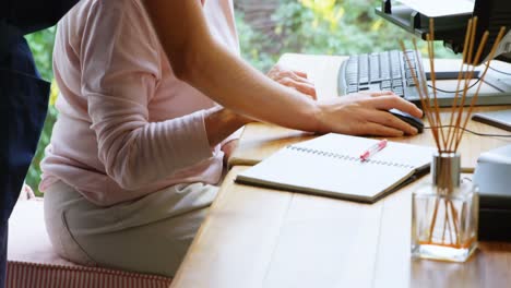 Physiotherapist-discussing-with-senior-woman-on-desktop-pc-4k