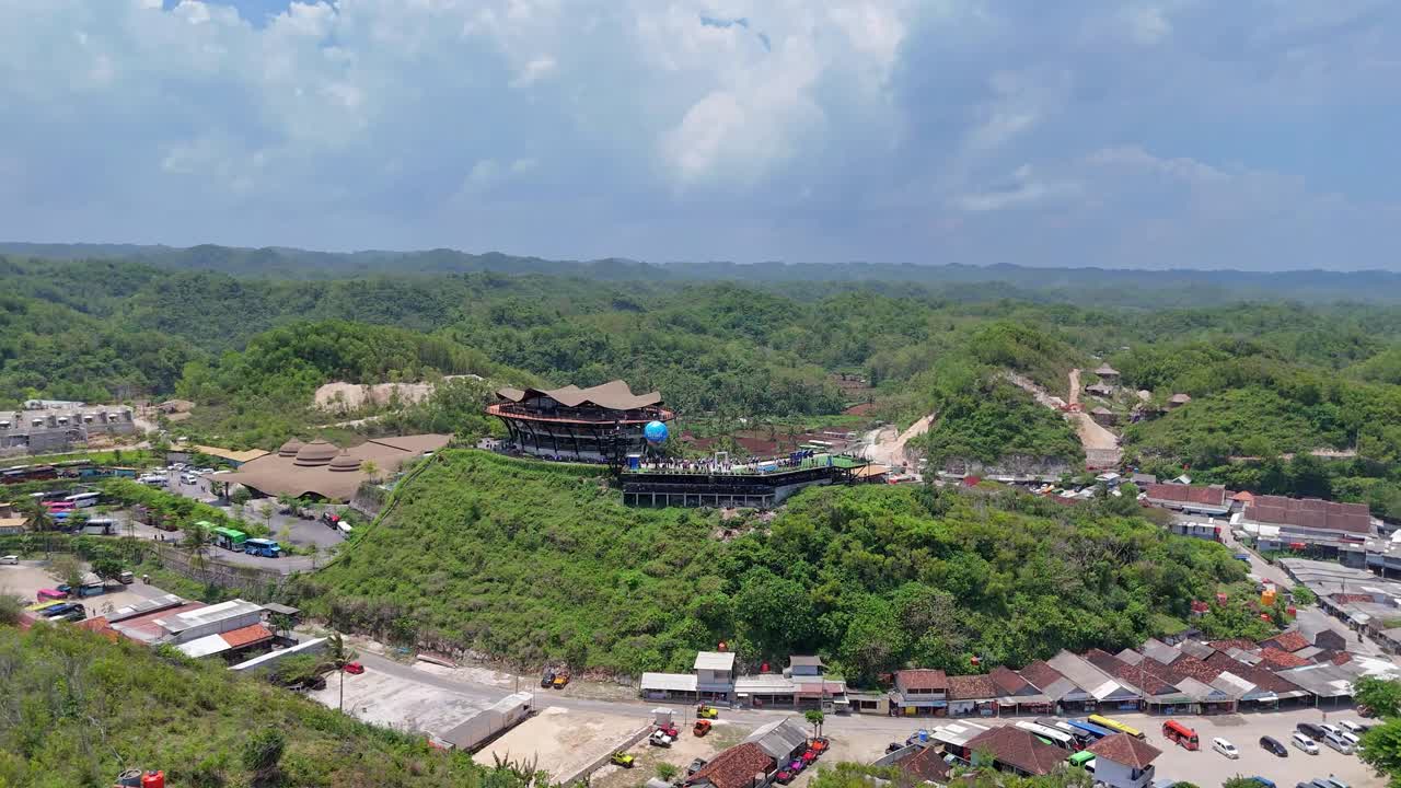 Aerial view of a building on a hill surrounded by nature