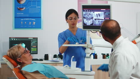 doctor pointing on digital screen showing dental implants