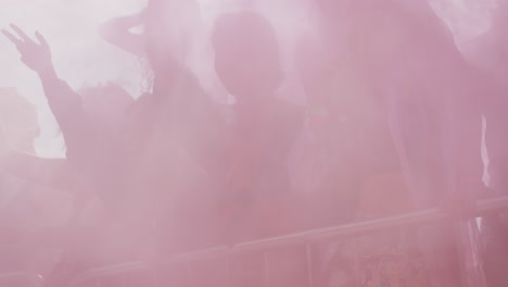 group of young friends dancing behind barrier at outdoor music festival