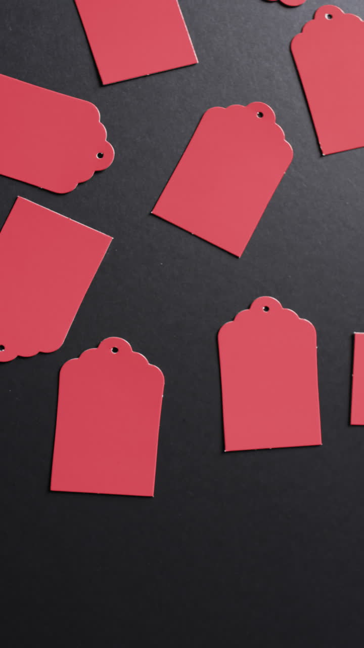 Vertical video of red price tags with copy space on black background