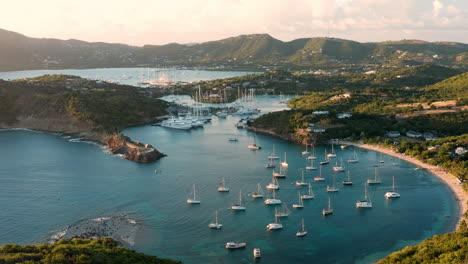 toma aérea de la puesta de sol en puerto inglés en antigua, caribe con vistas de yates, veleros, puerto deportivo, bahía y acantilados