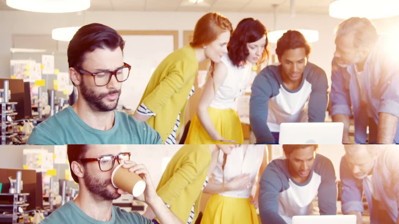 ejecutivo masculino usando una tableta digital mientras sus colegas trabajan en segundo plano