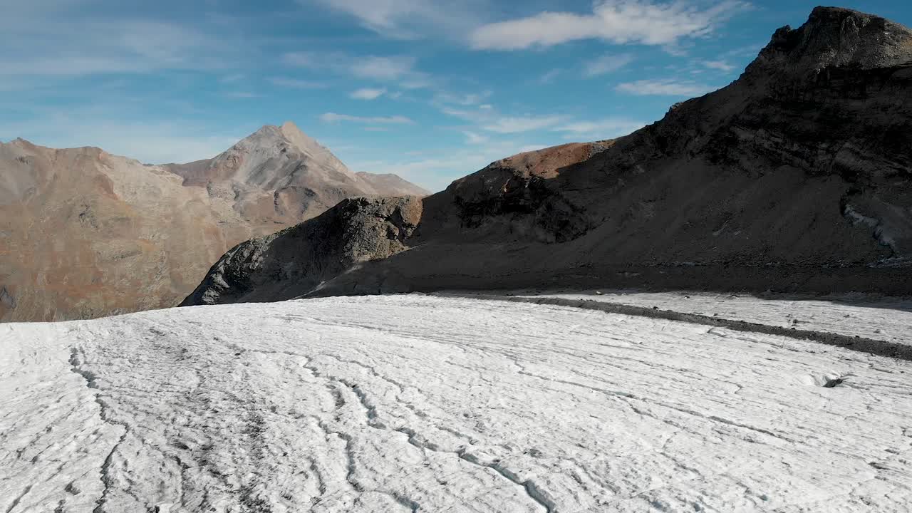 sobrevuelo aéreo alrededor de un excursionista y el hielo del glaciar allalin cerca de saas-fee en valais, suiza en un día soleado en los alpes suizos