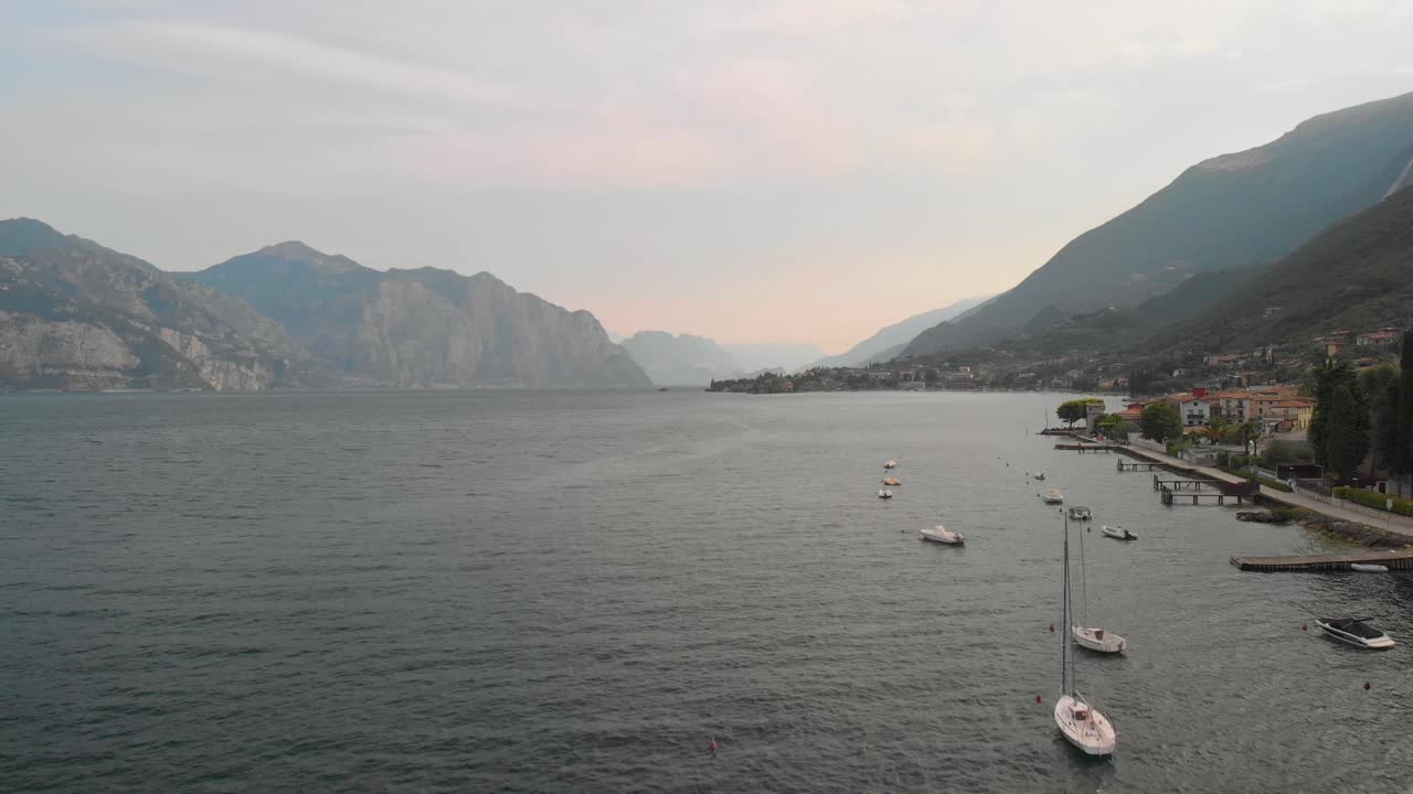 Una ripresa aerea professionale sul Lago di Garda, volando proprio sopra il lago e alcune barche all'alba.