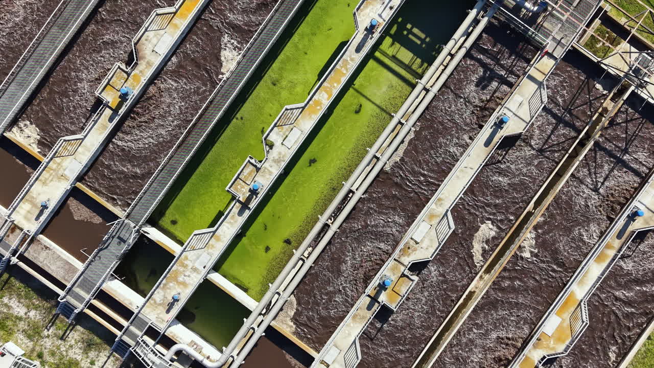 View of a water treatment facility showing the process of filtration and separation of water and waste materials at midday