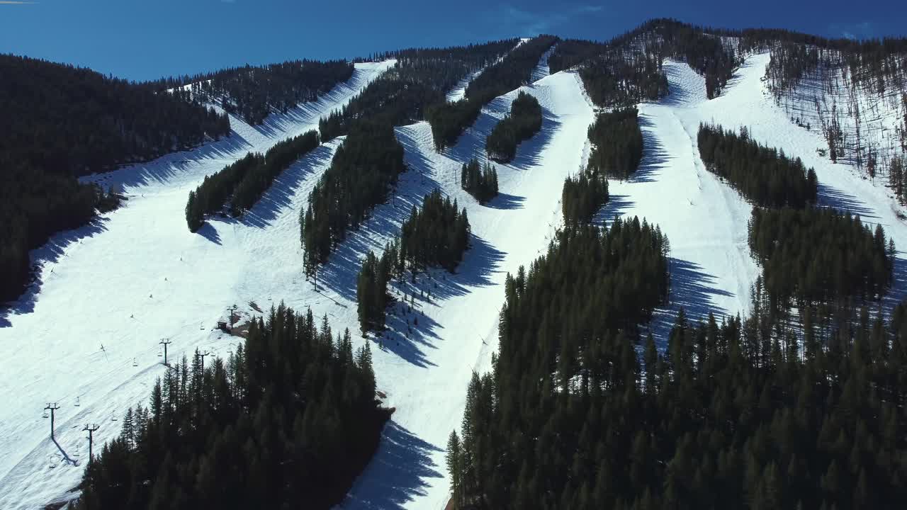 vista aérea de las laderas de las montañas cubiertas de nieve con bosque de hoja perenne en invierno