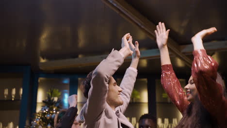 a couple dressed in elegant clothes dance with friends at the new year's party