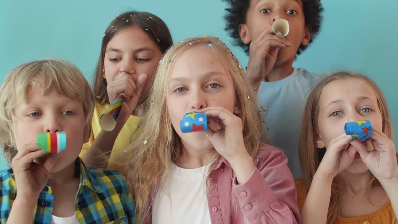 niños tocando cuernos de fiesta en la cámara