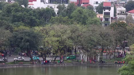 people and vehicles around hanoi lakefront