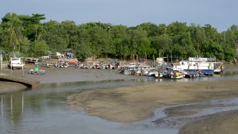 Boats-moored-at-pier-mooring-low-tide,-Changi-Beach,-SIngapore