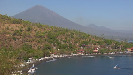 a white boat pulls into a harbor in indonesia